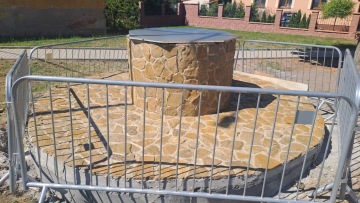 Obložení studny kamenem.