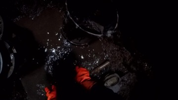 Vybírání nánosu ze dna studny.