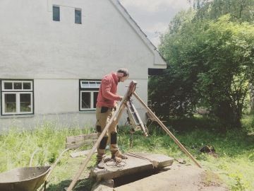 muž připravuje čištění studny na chalupě