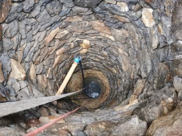 Čištění staré kamenné studny nedaleko Plas.