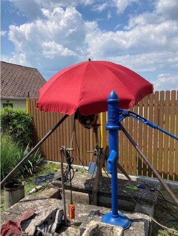 Čištění kopané studny v létě.