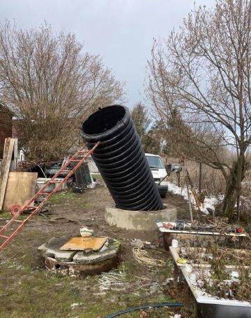 Spouštění plastové skruže do studny.